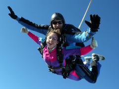 Tandem jumpers with arms out in free fall.