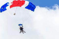 Tandem jumpers with clouds in the background.