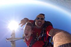 GoPro photo of two skydivers with plane overhead.