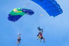 Two sets of tandem skydivers.