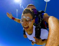 A young man smiles as he skydives.