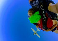 Skydive in clear blue skies as the plane passes overhead.