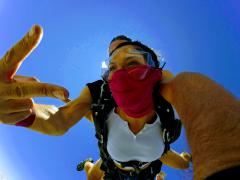 A young woman skydiving on a sunny day.