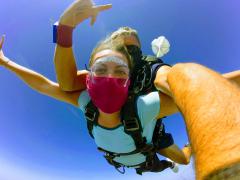 A young women skydiving with arms out enjoying the free fall.