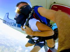 Tandem jumpers leaping out of the cabin.