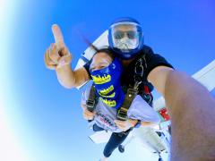 Skydivers with plane passing overhead.