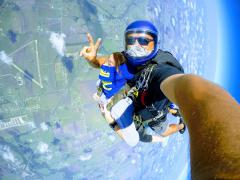 Two skydivers high above the landing zone.