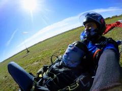 Tandem skydivers sit on the ground moments after they landed.