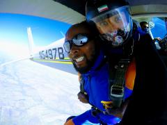 An excited man gets ready to jump from a plane.